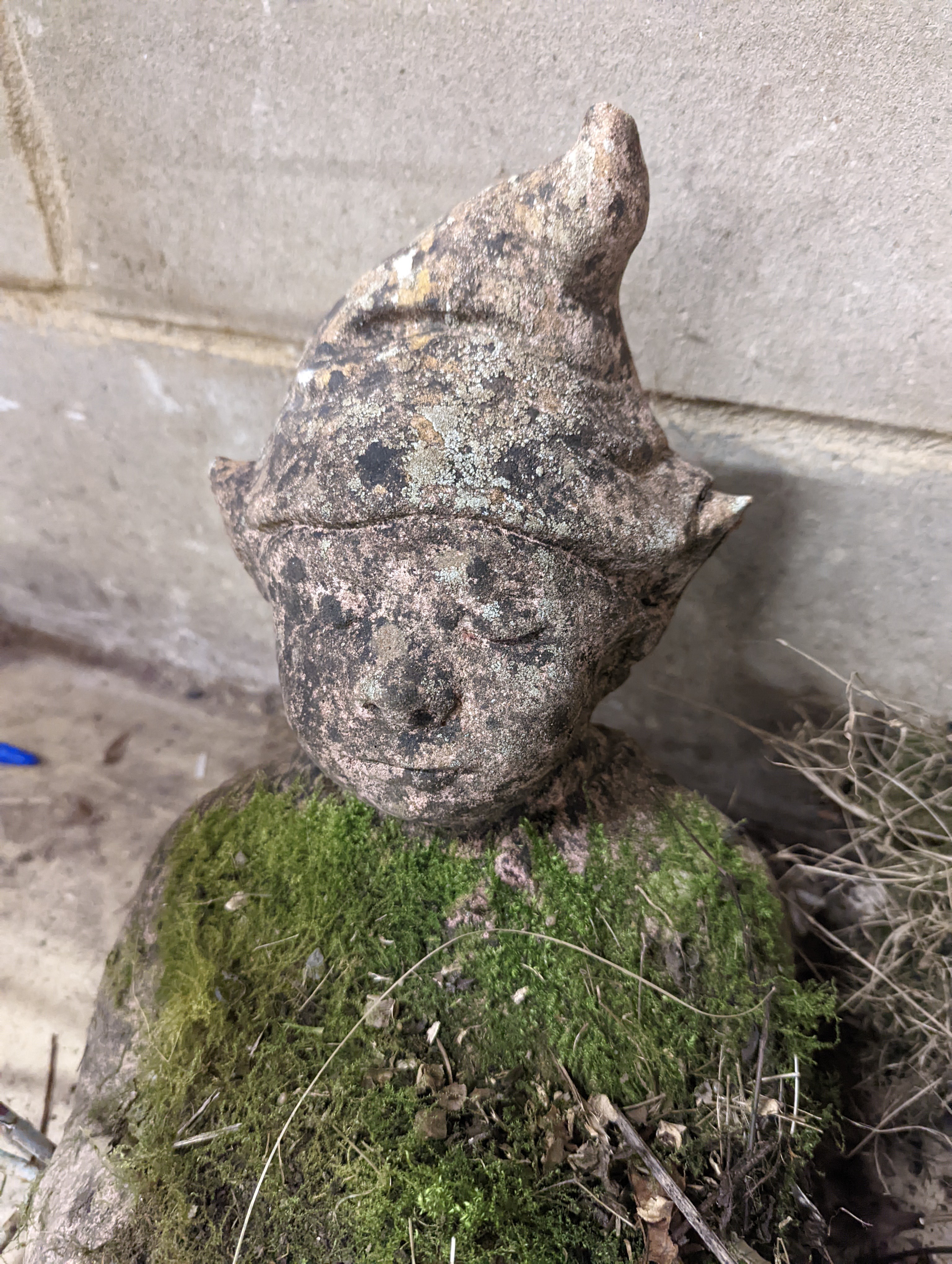 Two small circular mill stones, a reconstituted stone gargoyle and a terracotta reclining pixie garden ornament